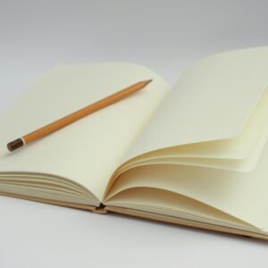 An open notebook with blank pages and a pencil, perfect for starting new ideas or journaling.