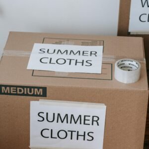 Labeled cardboard boxes for summer clothes ready for moving or storage, with packing tape and labels.