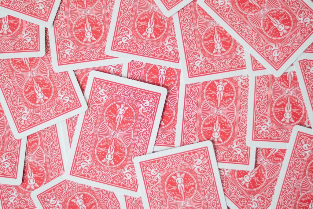 Colores 1 Red playing cards scattered creating an intricate and ornate pattern for gaming or decor.
