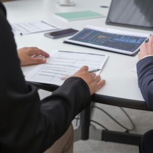 Close-up of professionals reviewing documents in an office setting, focused on analytics.